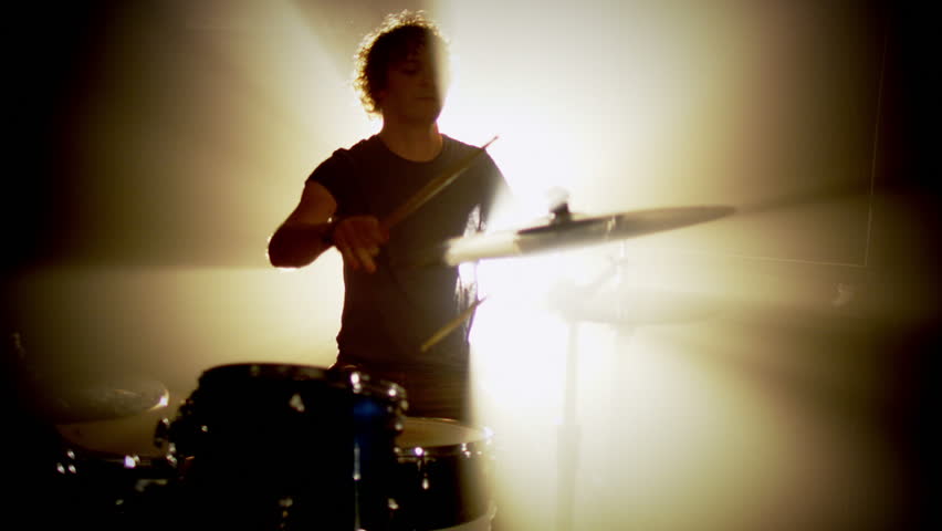 Concert rock band performing on stage with singer performer, guitar, drummer.  Music video punk, heavy metal or rock group.  Slow motion instrument playing band of men.