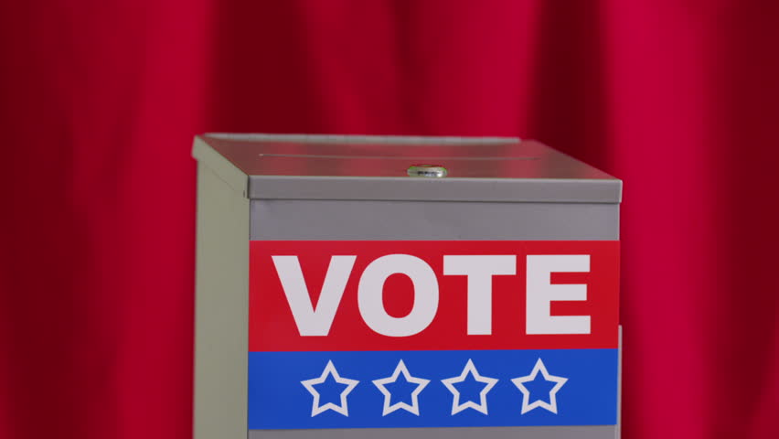 Hand putting vote into ballot box