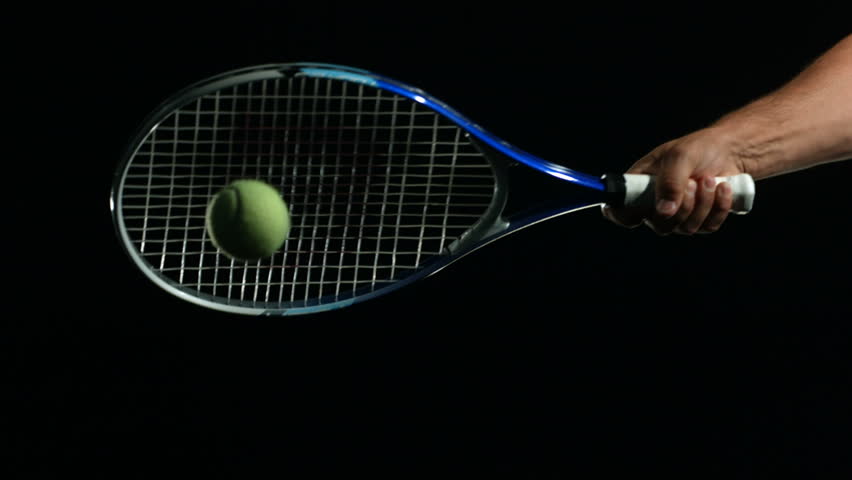 Tennis Ball being hit in slow motion against black background