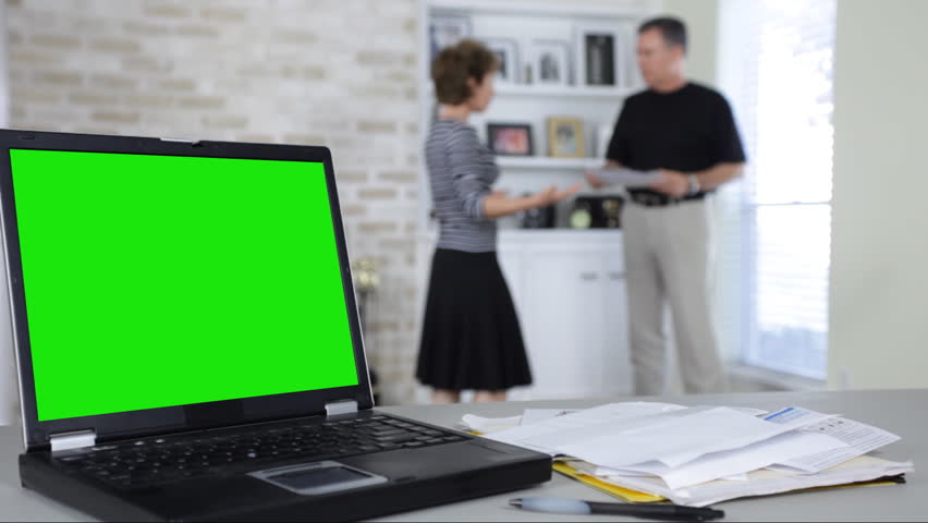 A couple with financial woes quarreling and making accusations. Main focus is foreground, with background out of focus.