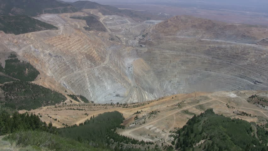 Kennecott Copper Mine central Utah. Zoom in. Above looking into open pit. Butterfield Canyon Ophir Mountains near Salt Lake City. Mountain forest around open pit.  .