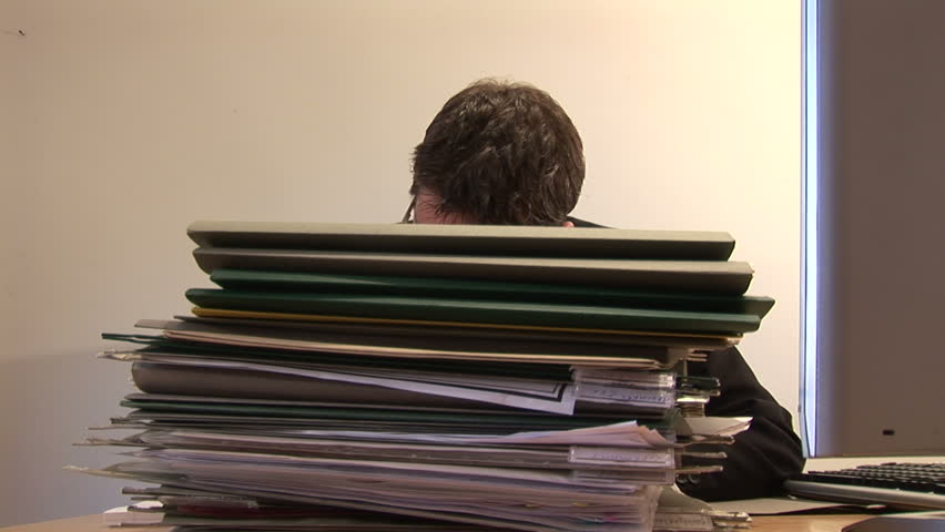 Businessman at Work With Stack of Documents