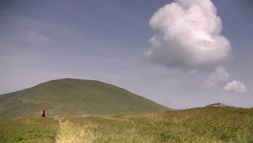 Girl hiking in mountains with trekking poles, HD. Ukraine, Carpathians