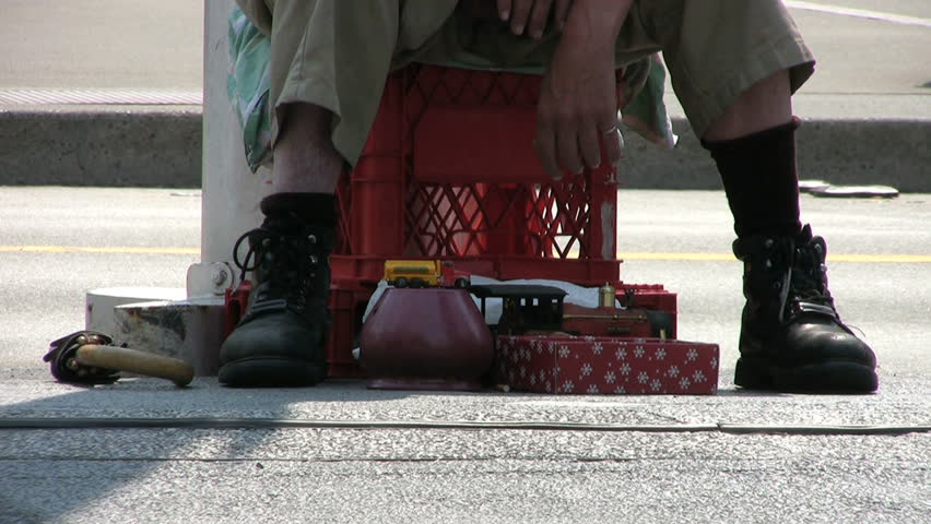 A shot of a homeless, down and out man tries in vain to sell his old items to bring in some cash for food. 