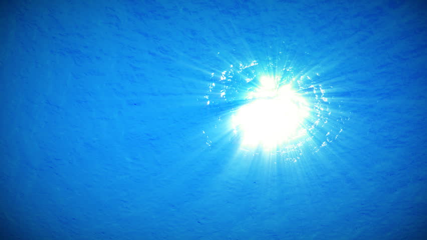 An underwater clip of a calm ocean surface with sunlight shining down through the deep waters of the sea.  HD 1080p clip - seamless loop. 