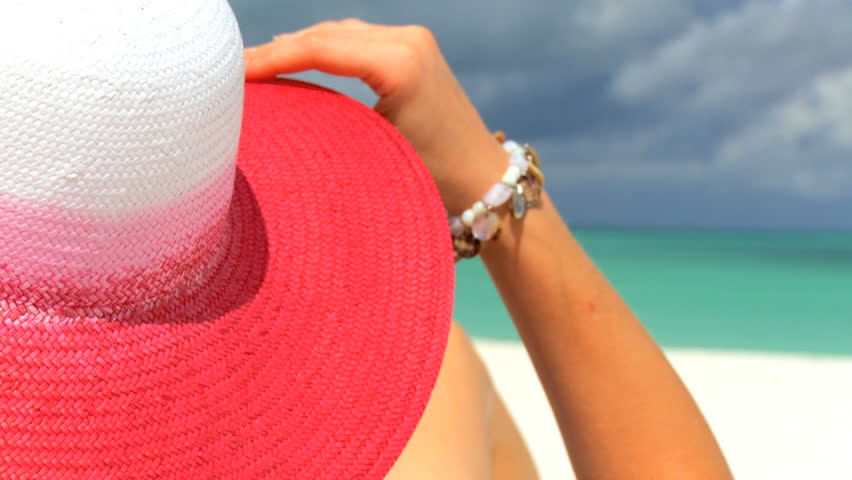 Elegant young female relaxing on white sandy beach looking at aquamarine waters 60 FPS