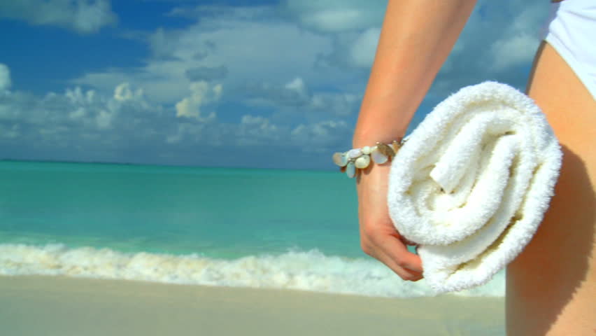 Elegant young female in swimwear  on a beautiful white sandy beach looking at aquamarine waters 60 FPS