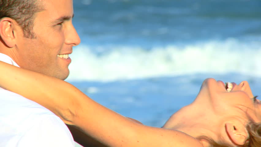 Two young people in love having fun on the beach early morning after a social night out 60 FPS 