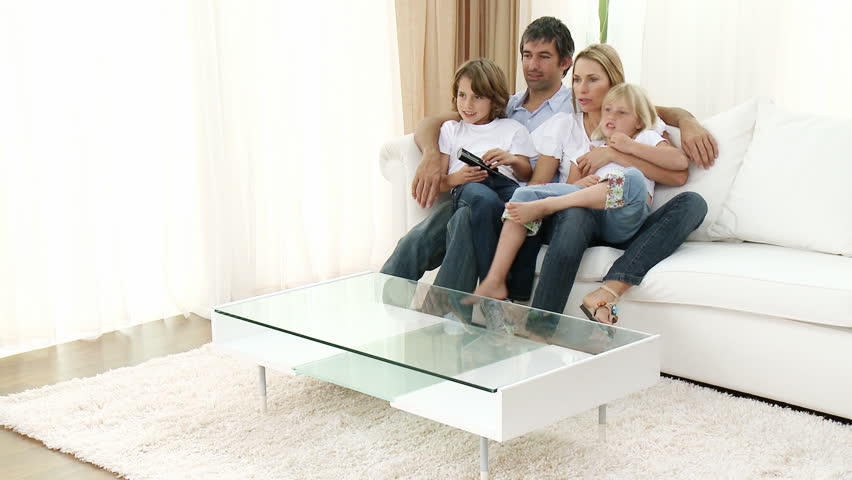 Family watching a football match and celebrating a goal at home. Footage in high definition 