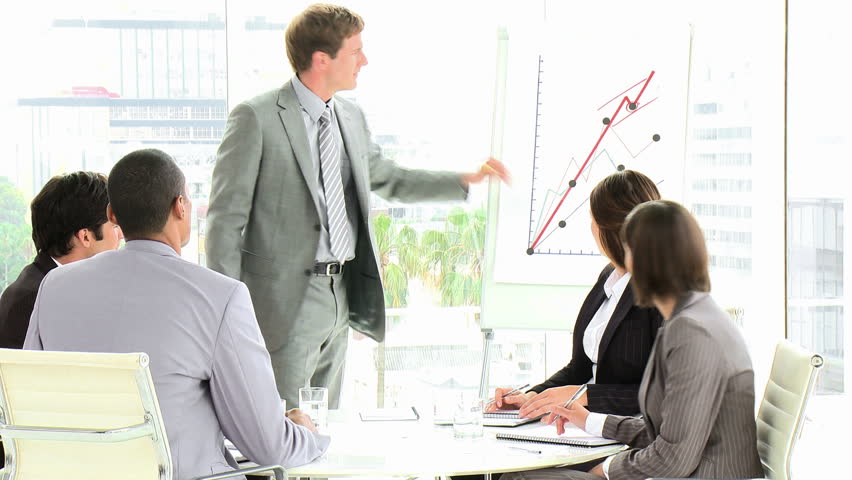 An Attractive Businessman Reporting Sales at Business Meeting: HD