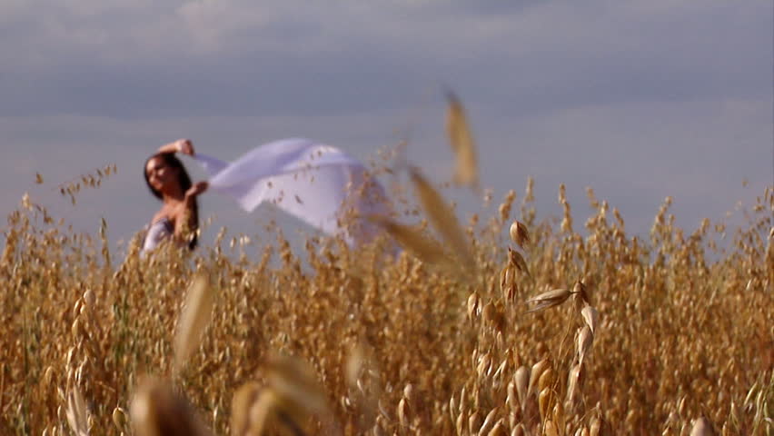 Close-up of wheat with happy woman with kerchief on background