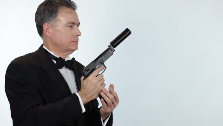 A man dressed in formalwear, readies his weapon, fires multiple times, then smiles with satisfaction.