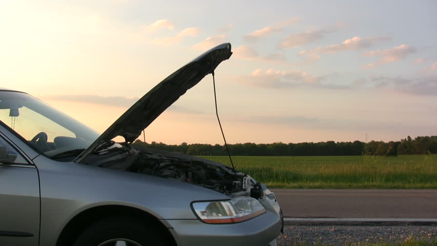 Man with broken down car on side of road