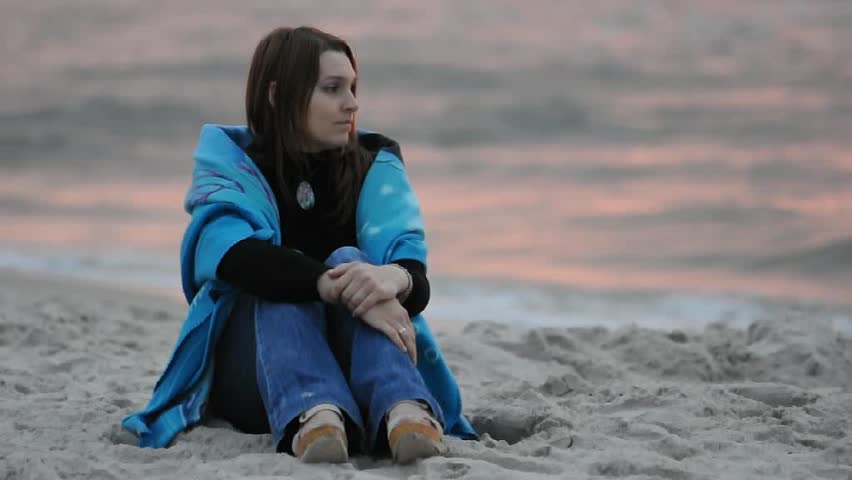 Girl sitting on sandy beach