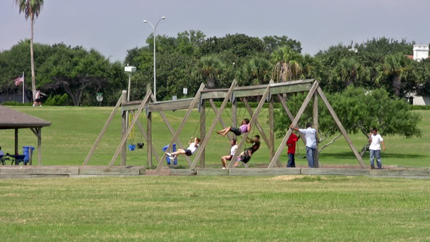 Video of playground chain swings in a kids or children park. Rubber seat moving in the wind. Kids activity and recreation. 