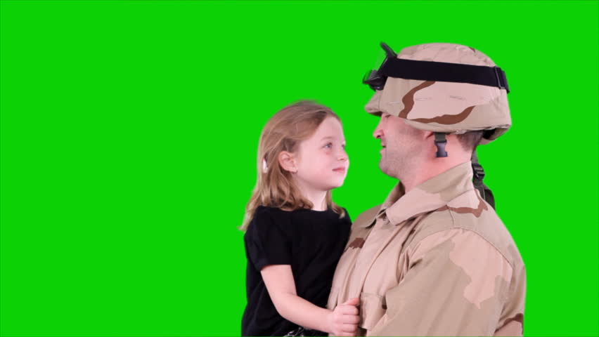 A happy father, who has just returned from the war, holding his little daughter who puts on her daddy's helmet.