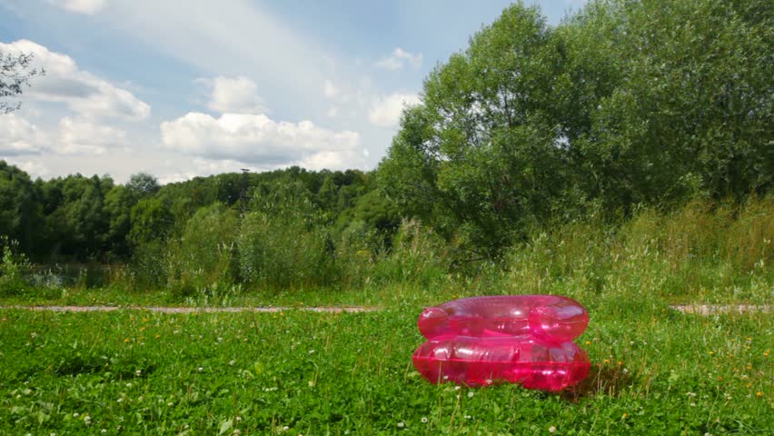 spectacled man goes and sits down on inflatable chair outdoors 
