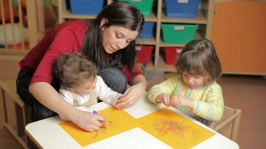 female teacher, toddler and 2-3 year girl drawing in kindergarten