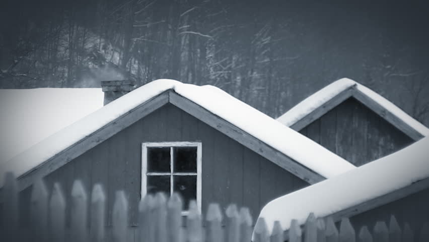 Country winter scenery. Snow-capped roofs with smoke from the chimney. Blue toned, HD