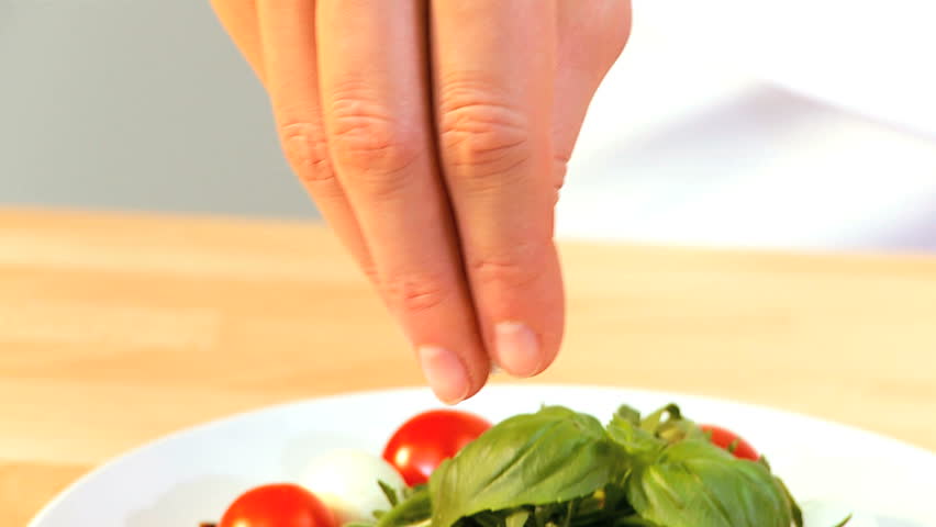 Tempting selection of fresh salad vegetables making a healthy nutritious meal being seasoned with rock sea salt