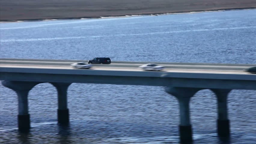 Aerial Police chase of Black Suv across bridge.  Point of view.