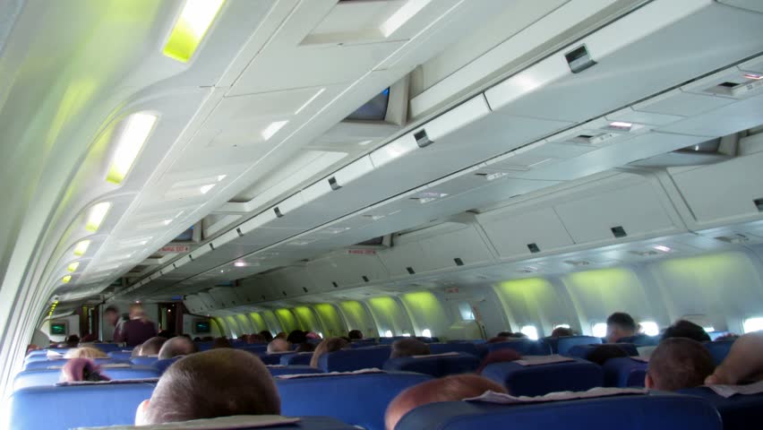 Plane salon: passengers sit, stewards approach to passengers. Time lapse. 