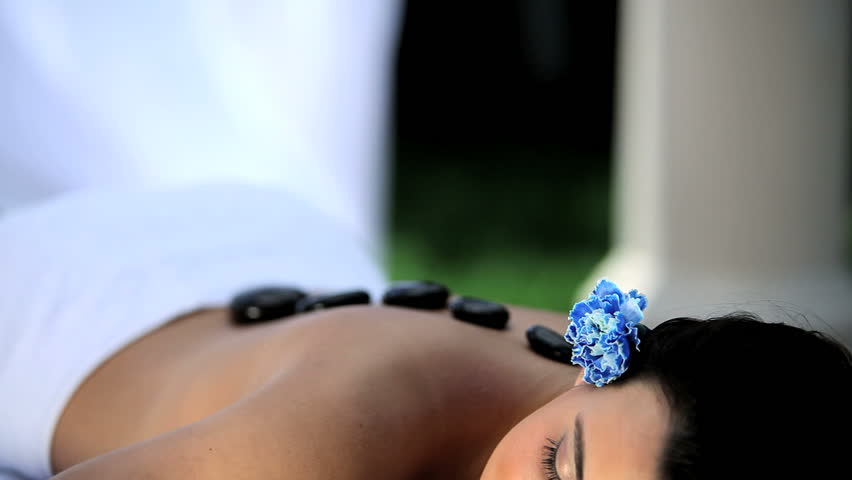 Beautiful young brunette girl having La Stone massage treatment at the health & beauty spa