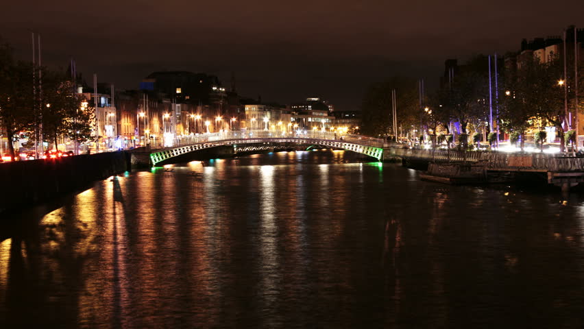 Time lapse of river Liffey banks with Ha'penny bridge in the background, at night in Dublin city, Ireland