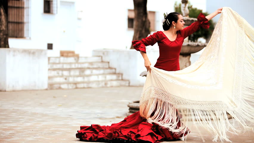 Beautiful spanish flamenco dancer with shawl in town square in Seville, Spain