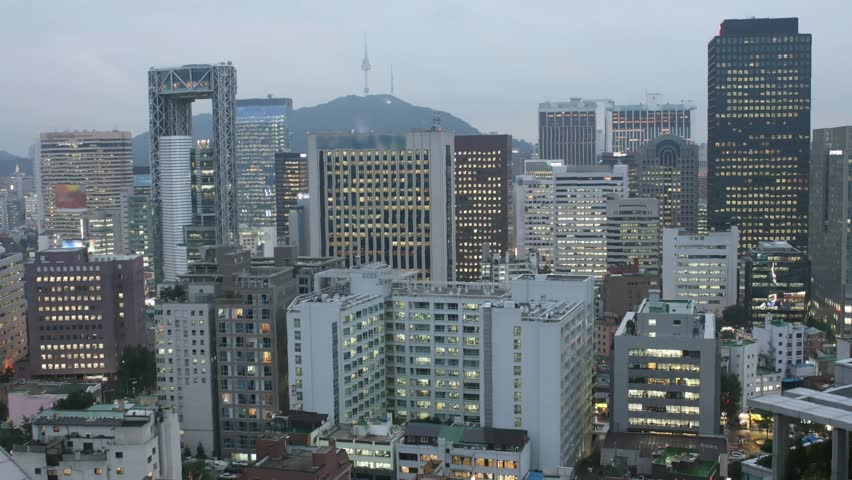 Time lapse cityscape of Seoul at twilight, South Korea. All trademarks and sign boards are blurred.