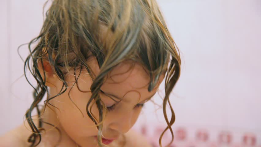 cute happy little girl dries by towel in bathroom