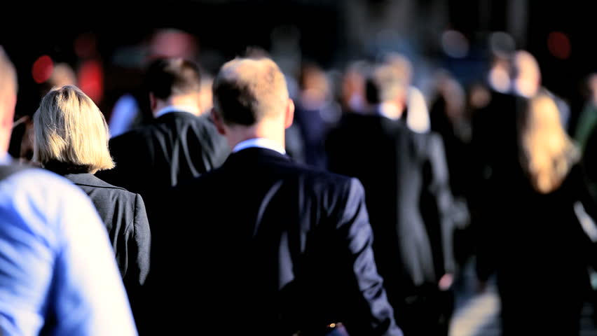 Early morning commuters walking to work in a busy city environment