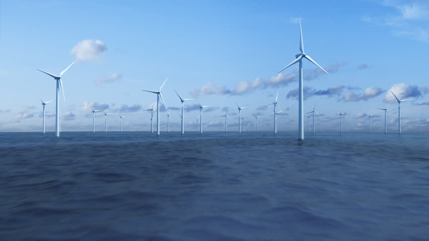 Camera flying over the ocean trough a farm of wind turbines.