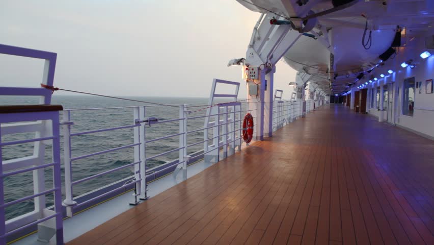 deck with illumination of cruise liner in evening sea