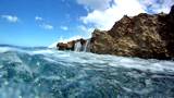 Ocean waves splash against a rocky shoreline before splashing the camera. Filmed in HD 720p at 60 fps