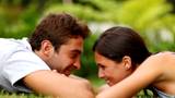 Romantic young couple enjoying themselves white lying on grass - Outdoor 