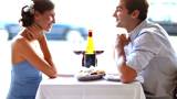 Wedding proposal; Happy young man giving a ring to a beautiful surprised young woman in a restaurant  