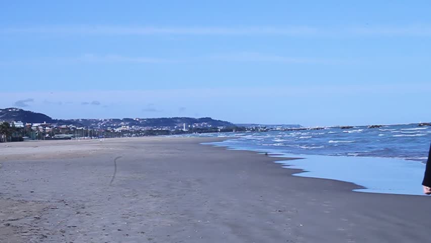 Middle-aged woman walks along the sea