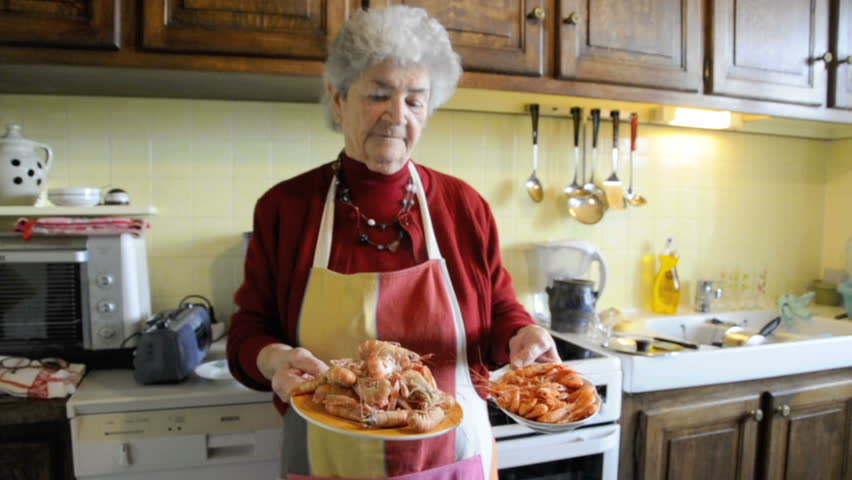 Senior woman cooking seafood in her kitchen