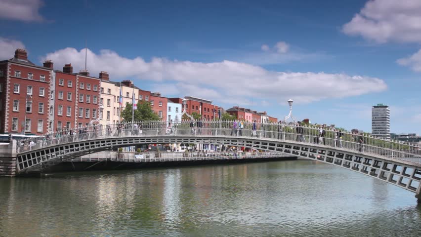 People walk on Ha'penny Bridge across River Liffey in Dublin, Ireland.