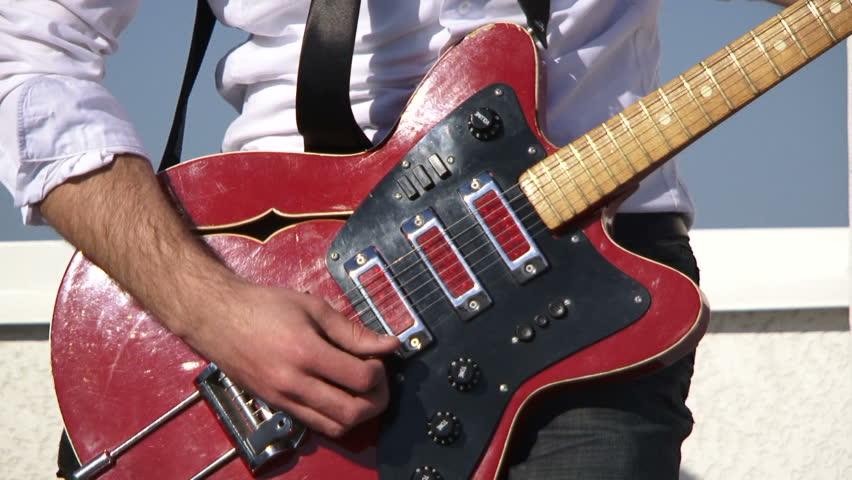 Rock musician plays guitar. Close-up.