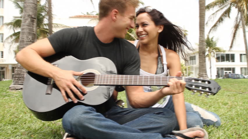 Young couple at park with guitar