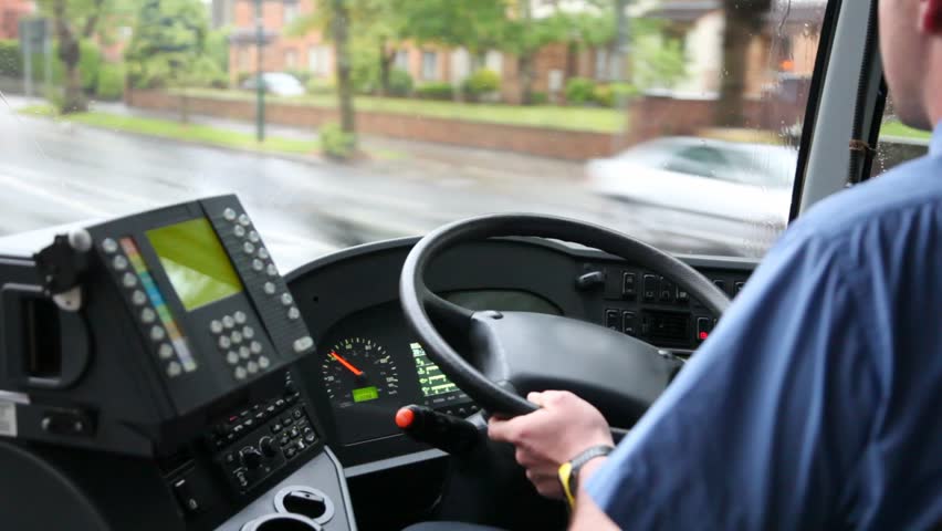 back view of man driving bus on  rainy road