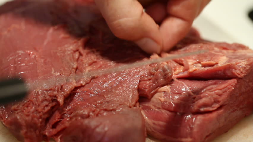 Man cuts the meat fat