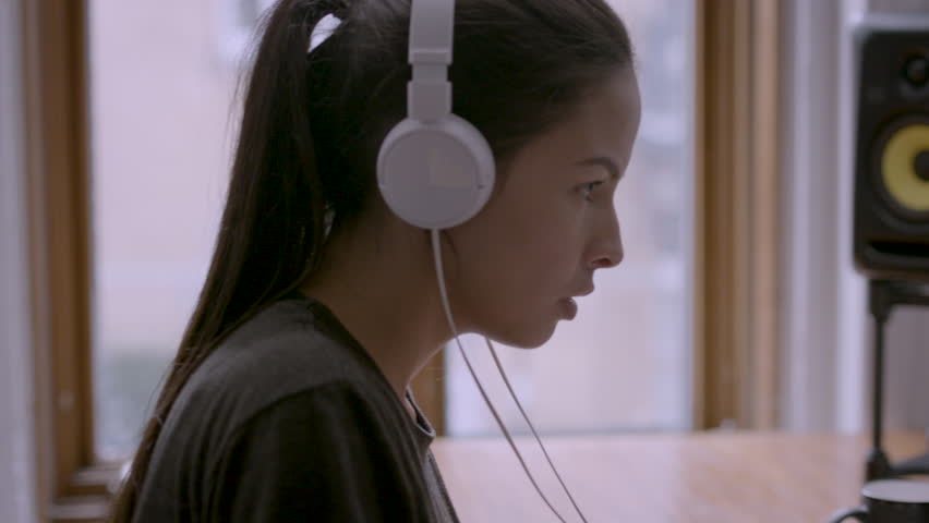 Close up of female working at computer and taking off headphones HD stock video. Alexa camera