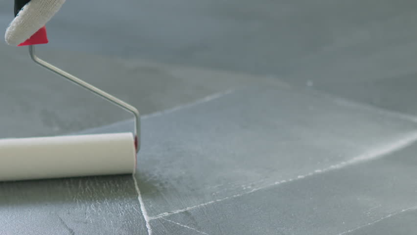Slow Motion Closeup Pan Applying Sealant On The Concrete Floor