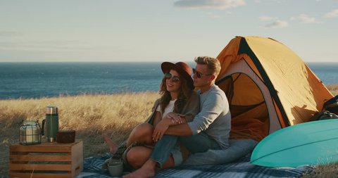 Attractive couple cuddling in comfortable camp site, summer surf adventure  hipster couple