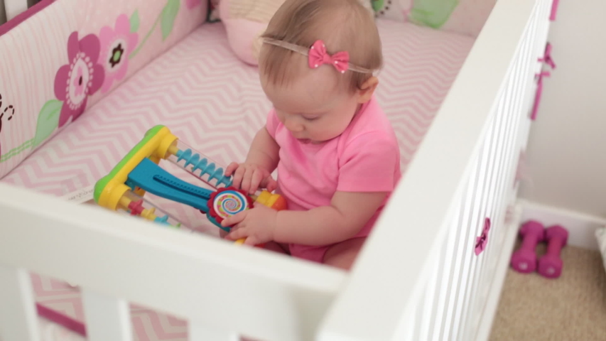 Cute And Adorable 8 Month Old Baby Girl Playing In The Crib Happy