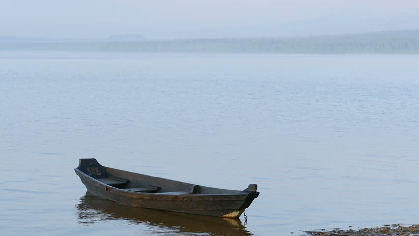 Stock Video Clip of Old small wooden boat on water. 4K 