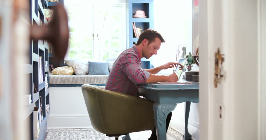 Working In Home Office view through door showing man working in home office stock footage Working In Home Office view through door showing man working in home office stock footage